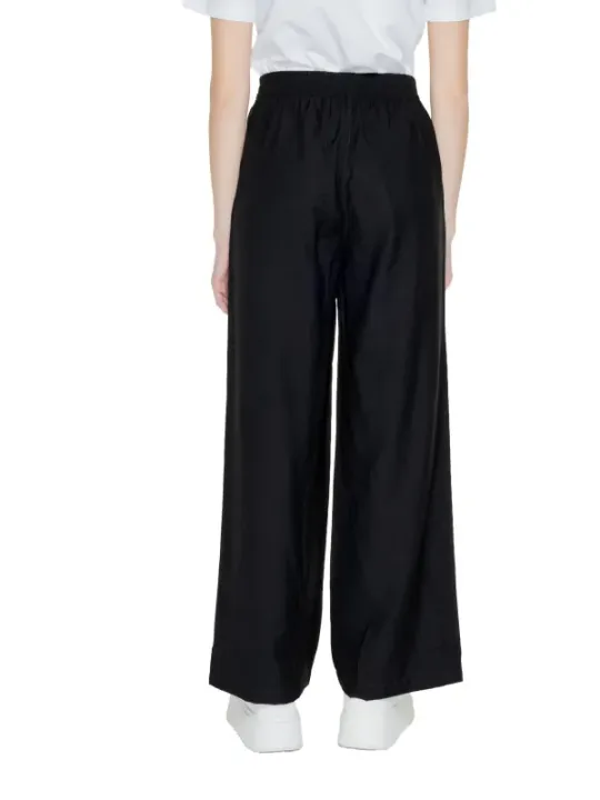 Weite schwarze Hosen mit Sneakern