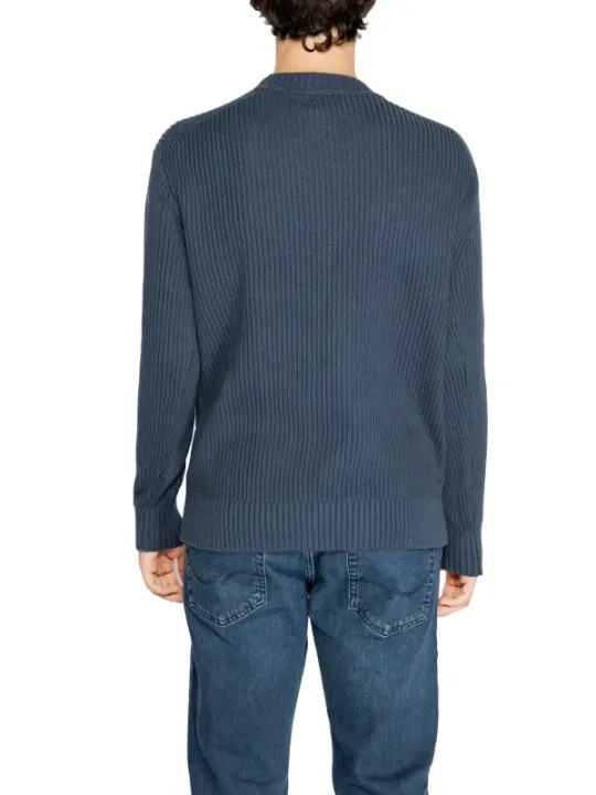 Person trägt grauen Calvin Klein Pullover