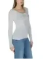 Schlanker Modell trägt graues Guess Top