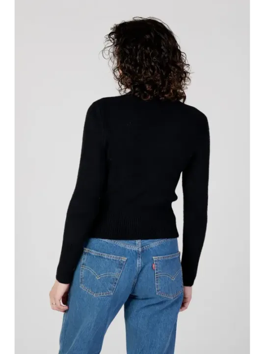 Frau trägt Guess Pullover Jeans