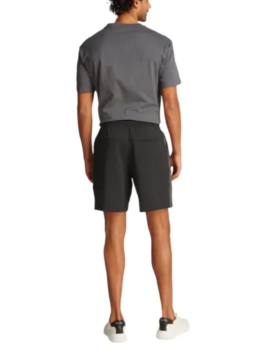 Graues T-Shirt, schwarze Shorts, Sneaker