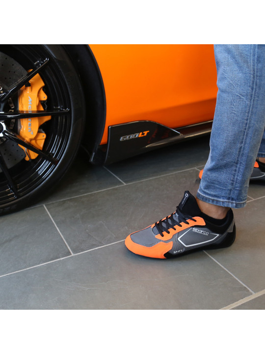 Graue Rennschuhe mit orangefarbenen Akzenten
